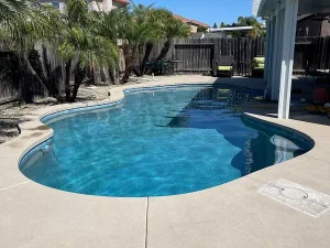 clear_swimming_pool_palm_trees_concrete_patio_blue_water_reflection
